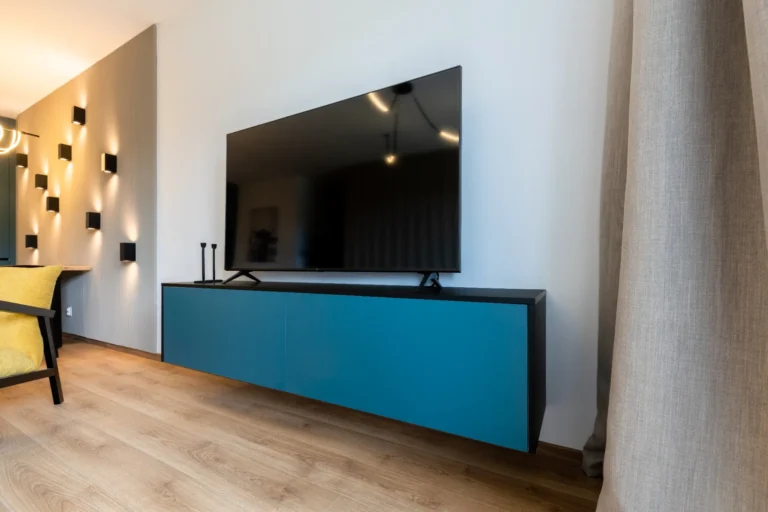 Detail zásuviek pod televízorom v spálni s úložným priestorom