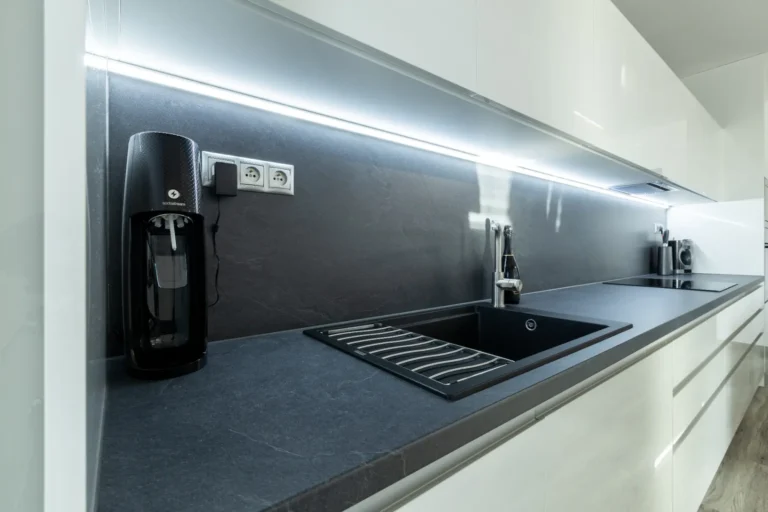 Detail kombinácie bielej lesklej linky a čiernych doplnkov v kuchyni