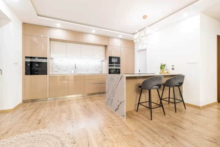 Celkový pohľad na elegantnú kuchyňu na mieru v Dolných Slažanoch s cappuccino akrylovým leskom a veľkým ostrovom z mramoru